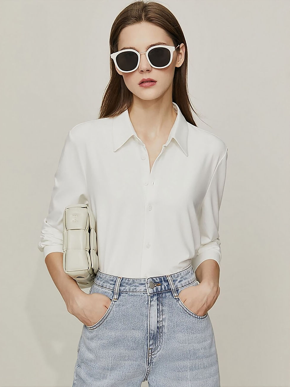 Une femme en chemise blanche avec des lunettes soleil