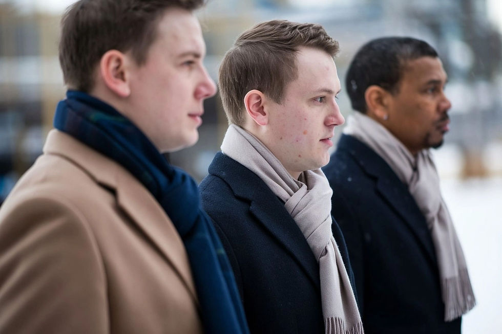 Portrait de trois hommes portant des manteaux d'hiver et des écharpes, vue de face.