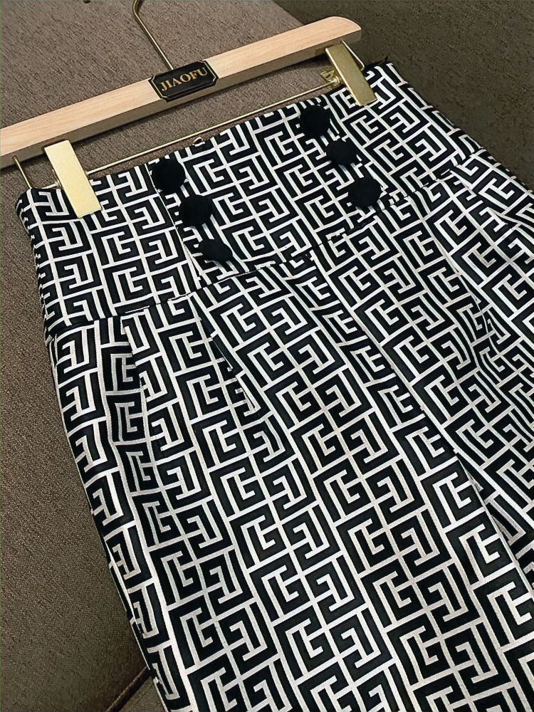 Jupe rayée noire/blanche avec des boutons noirs, souspendue sur un cintre, vue de face.
