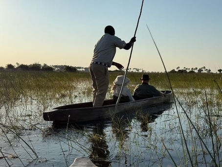 Tricia and Don being poled through the reeds in a mokoro.