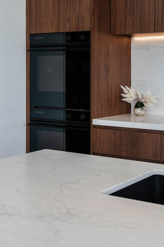 Walnut kitchen with black ovens
