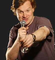 John Smith MC'ing pointing at audience member