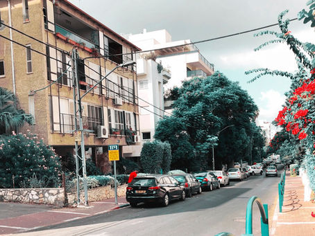 רחוב בגוש דן עם בניין חדש ליד בניין ישן