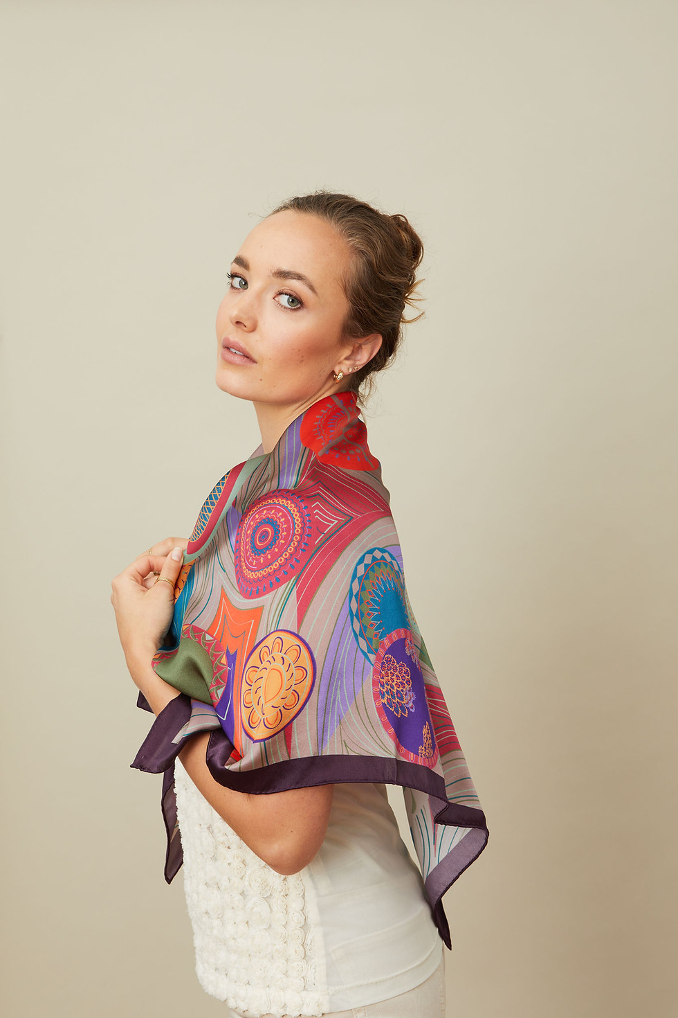 Model wearing a colourful scarf wrapped around the shoulders