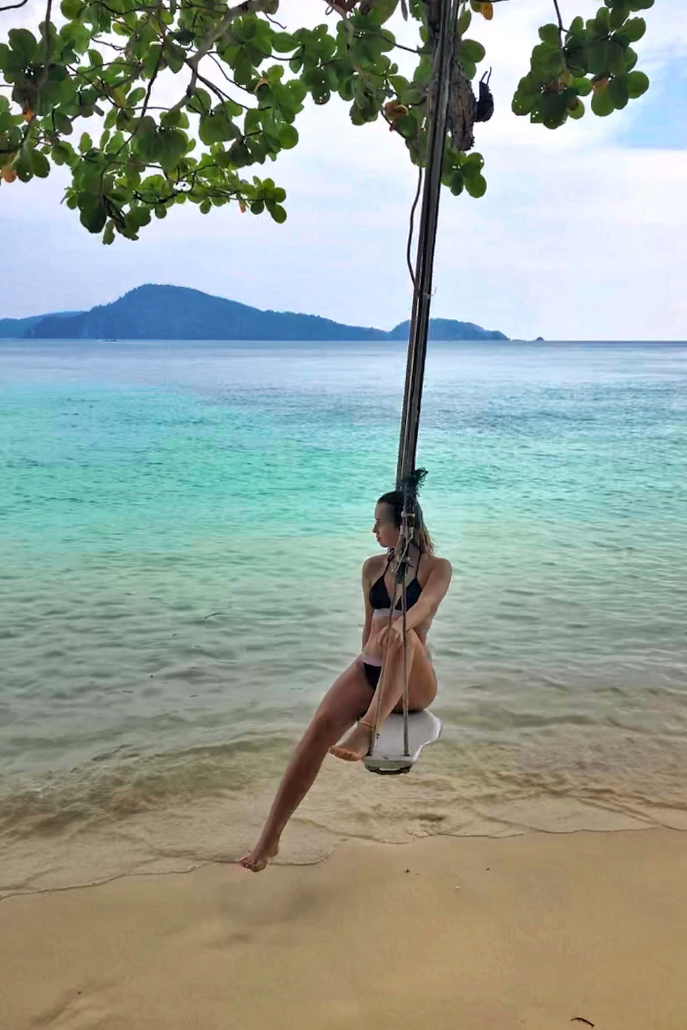 Girl on a swing at the beach