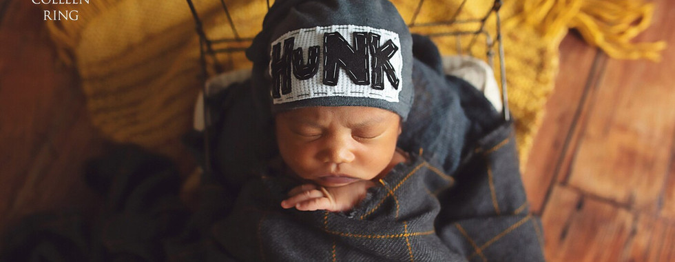 Award-winning newborn photo by Colleen Christi featuring a baby peacefully posed with delicate props.