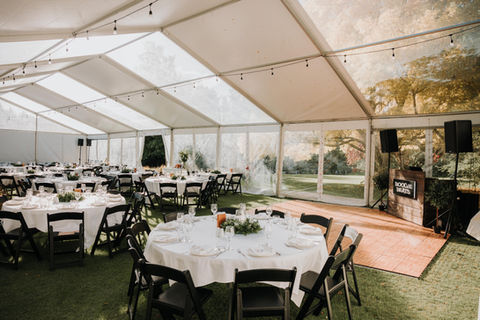 Daytime marquee wedding with round tables, clear roof panels and the Boogie Beats booth positioned near the side.