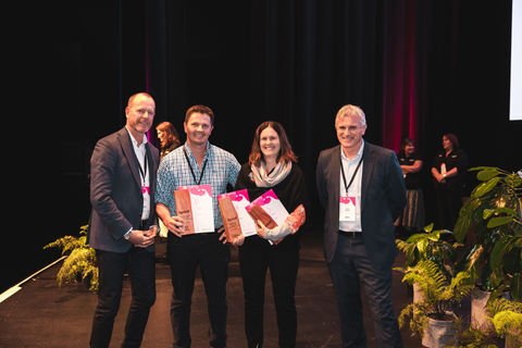Award winners on stage holding certificates at a Christchurch ceremony – corporate awards photography.