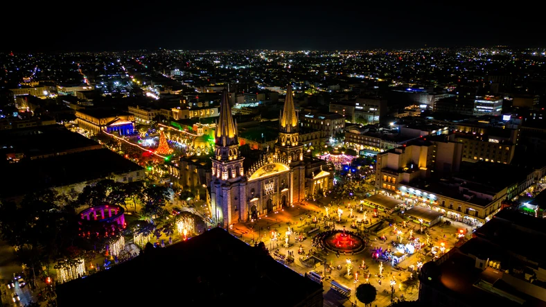 Vista aérea de la ciudad del centro histórico y la catedral de Guadalajara iluminados en la noche.