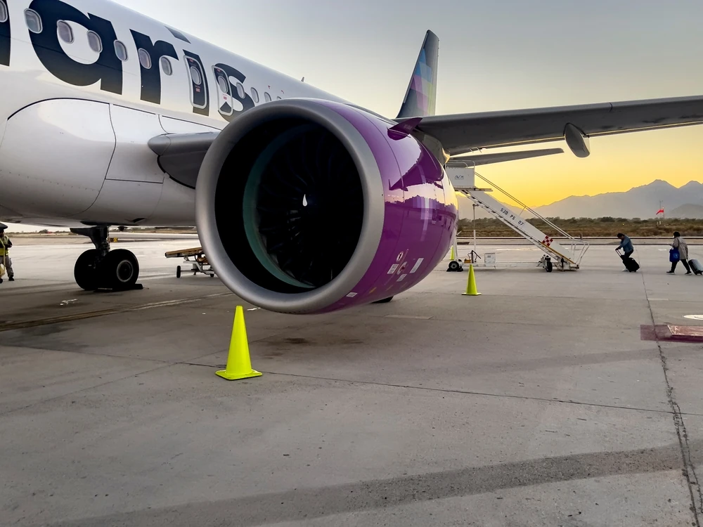 Detalle de una turbina de un avión de Volaris en la pista del aeropuerto.