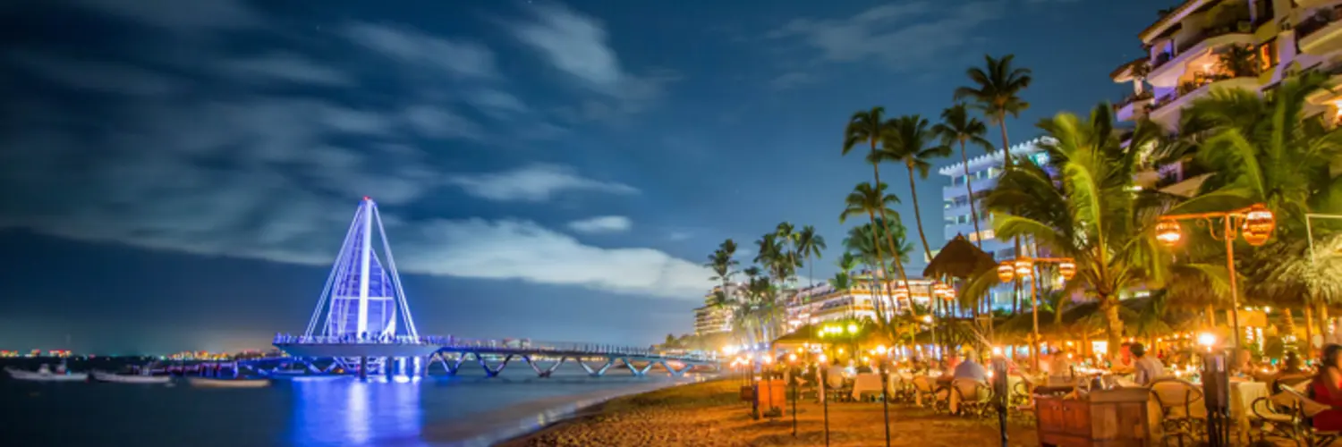 Costa de Puerto Vallarta y Malecón iluminados al anochecer