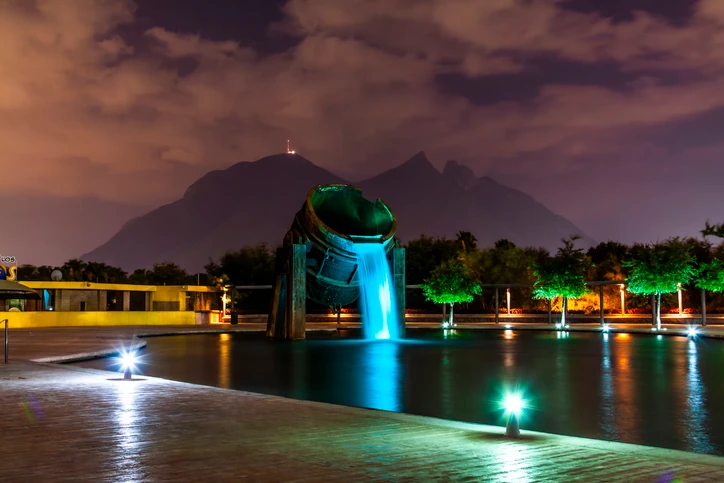 Fuente Horno 3 de Parque Fundidora en los lagos del Paseo Santa Lucía, iluminado al anochecer.