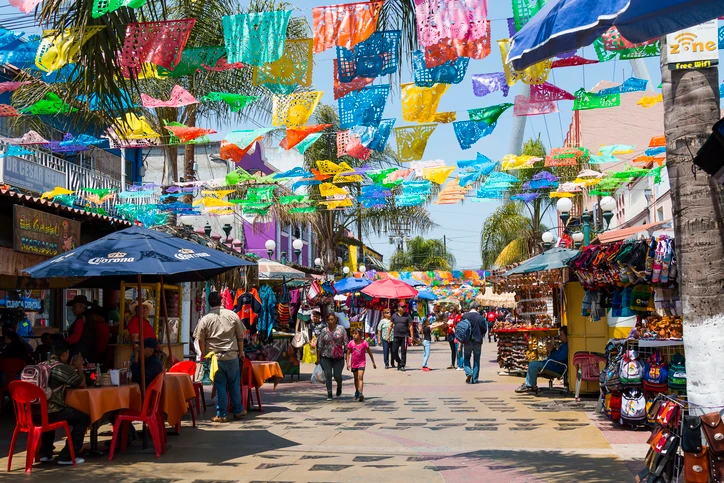 People strolling on a street of Tijuana’s Zona Rio filled with bars and artisan shops.