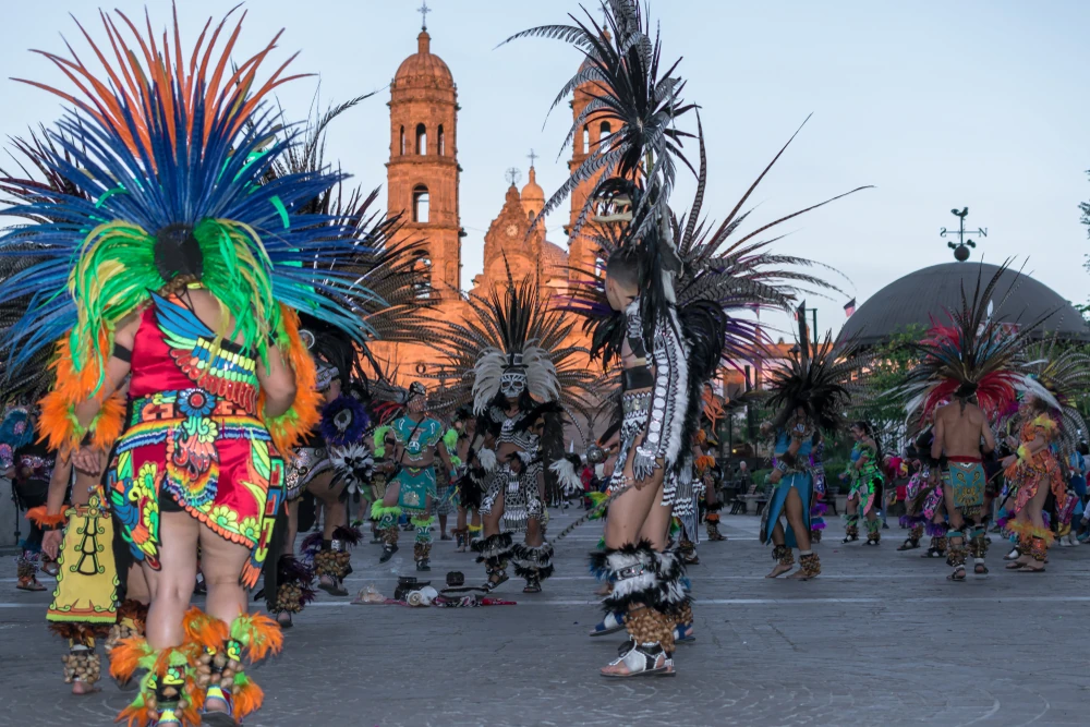 Grupos de bailarines vestidos con trajes de carnaval mexicano frente a la basílica de Zapopan.