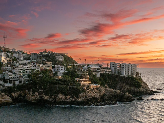Panoramic view of Acapulco skyline and an orange sky in the afternoon.