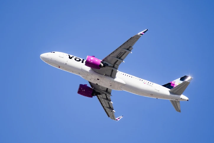 Avión de Volaris visto desde abajo sobrevolando un cielo azul.