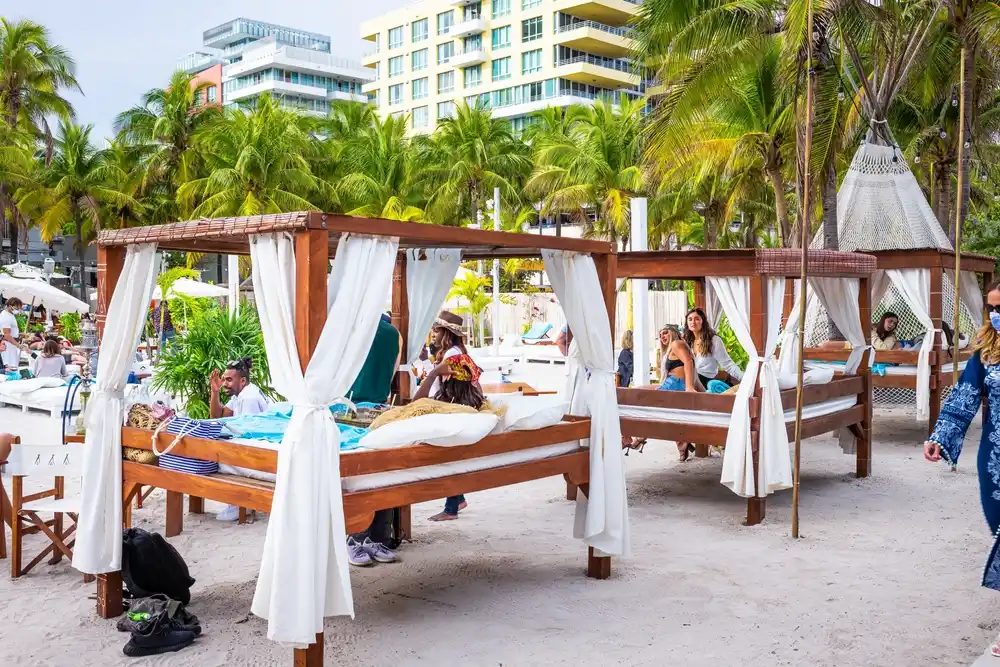 Gente se relaja en camastros en South Beach, Miami.