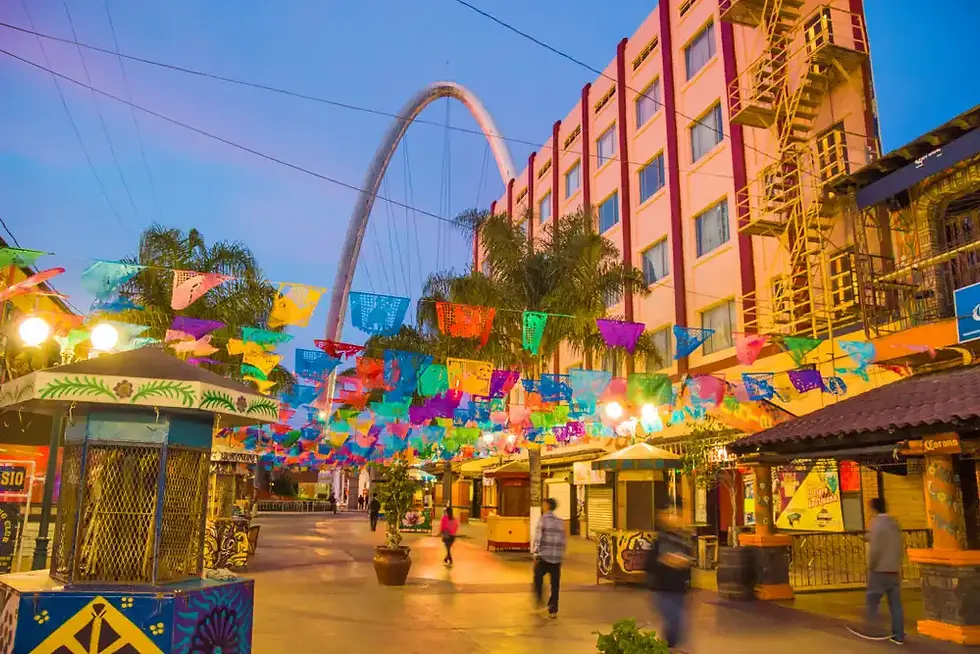Plaza al atardecer con banderines de colores, en Tijuana.