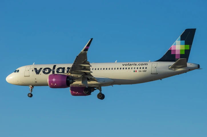 Volaris airbus flying across a blue sky.