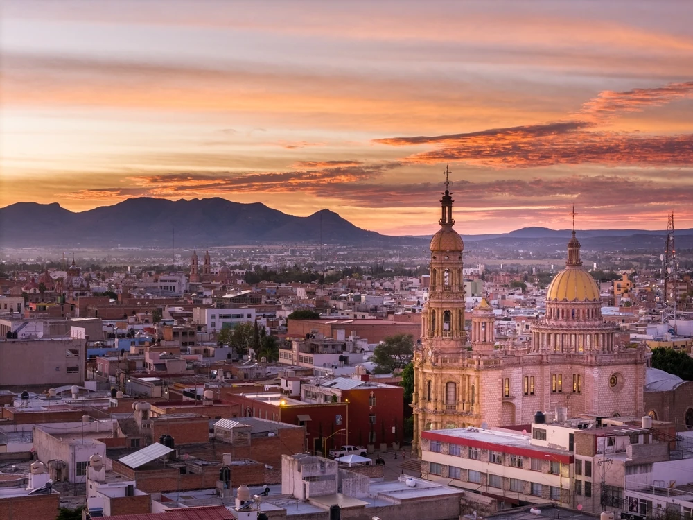 vista aérea de la ciudad de Aguascalientes desde su centro histórico, al atardecer.