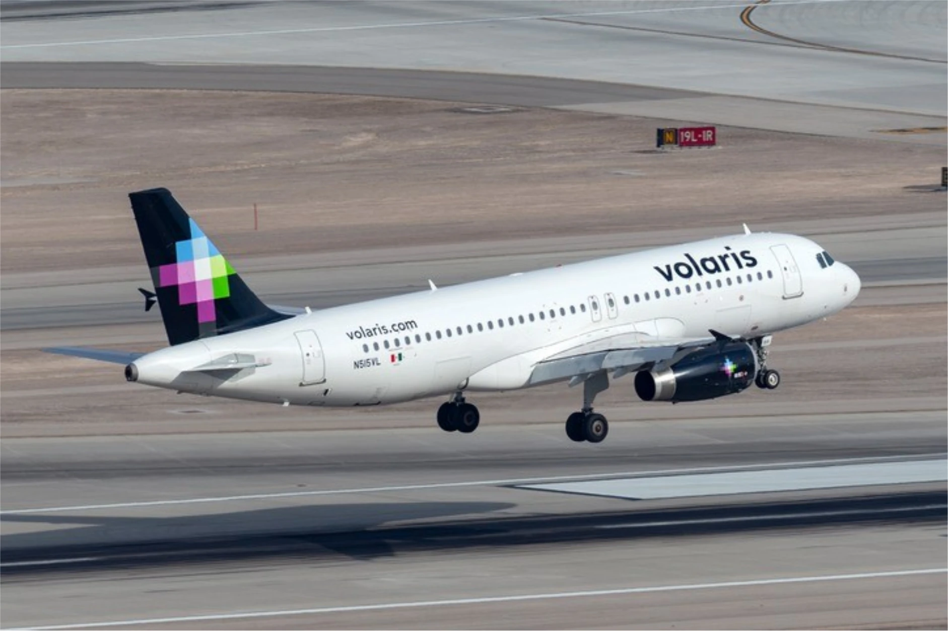Avión de Volaris en pista, con el logo y el mensaje "100 aviones para que más personas viajen bien".