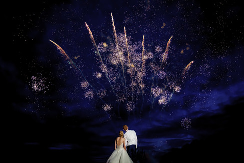 Couple watches fireworks display in night sky; Ever Thine Film & Photography.