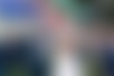 Couple laughing with their wedding party holding flares