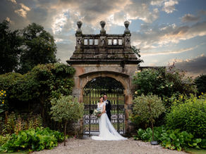 Newlyweds Standing by the gates of Tissington hall