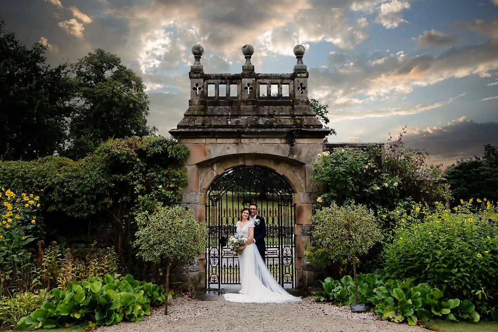 Newlyweds Standing by the gates of Tissington hall