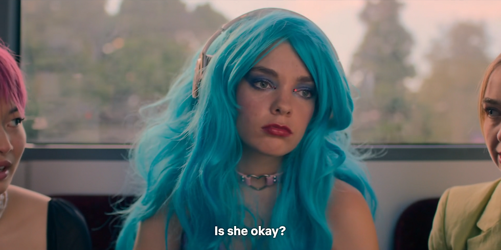 Quinni looks off into the distance, centred in frame with Sasha and jules cut off the edge either side of her. Subtitles, spoken by Jules, read: Is she okay?