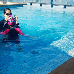 Swim instructor with two kids learning in pool