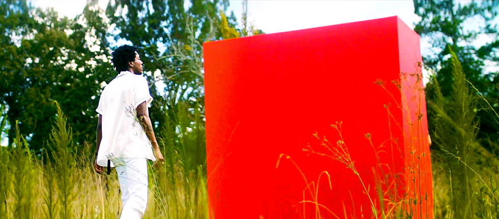 Singer DWN2Earth approaching a red monolith in a green field