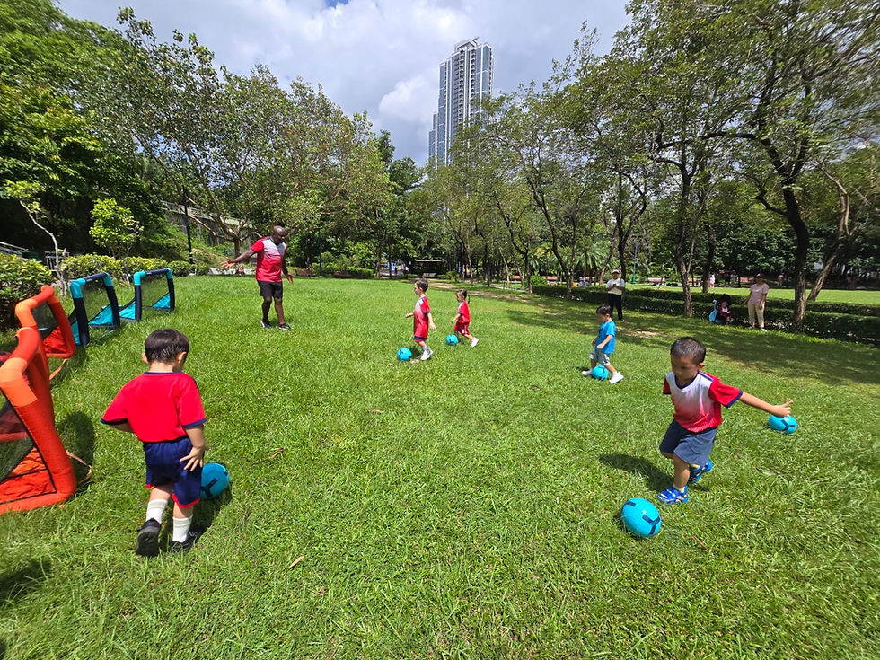 Eye-level view of a children’s football training session on a green field