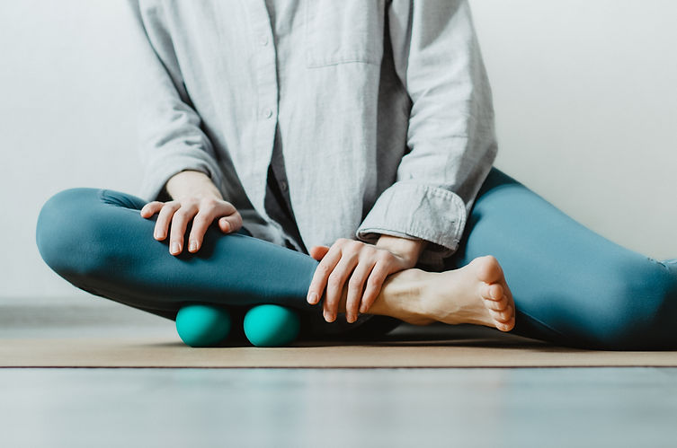 Person doing self myofascial release on shin muscles with two therapy balls.jpg
