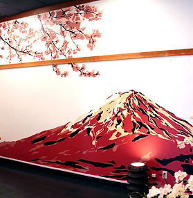a hand-painted mural of a red stencil-stylized mt. fuji with a cherry blossom branching down from the top left at Izakaya Akatsuki in Gardena, CA
