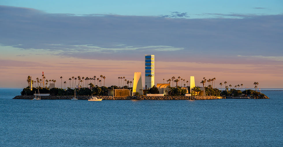 Island White artificial oil island at golden hour in Long Beach harbor with palm trees modernist architecture and sailboats a