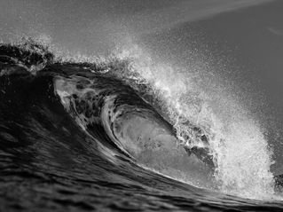 Black and white photo of curling wave at River Jetty, Newport Beach