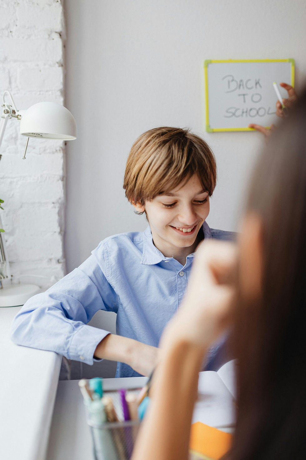 Learner smiles confidently at desk during a tutoring session, calm home office setting.