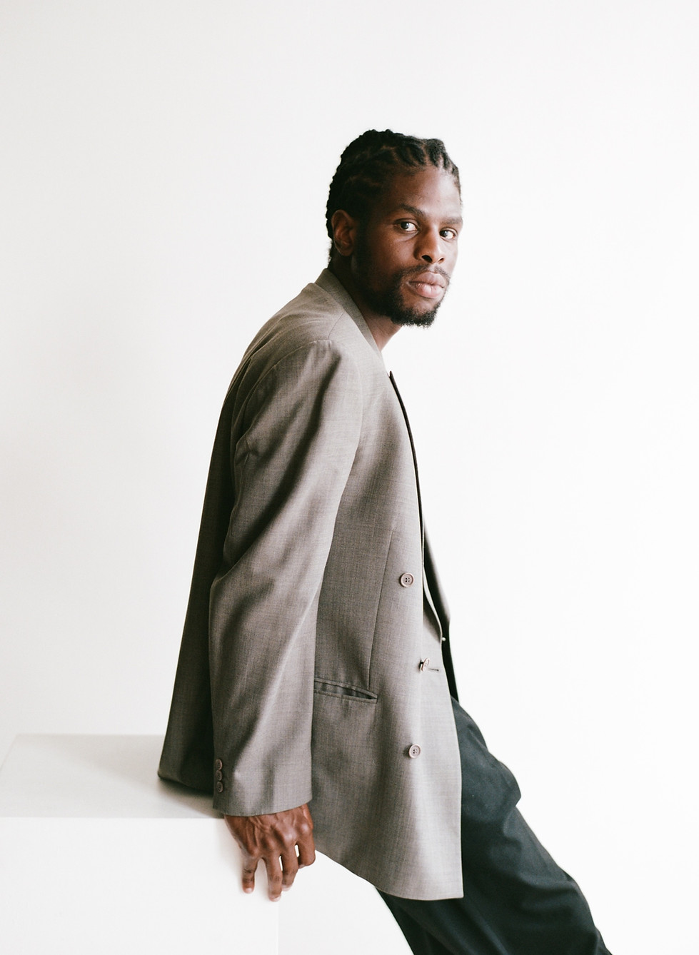 Male mentor in grey blazer looking over shoulder at the camera.