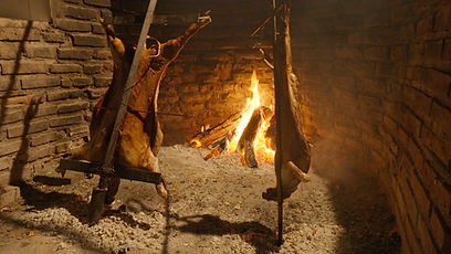 Lamb cooking in asado pit.jpg