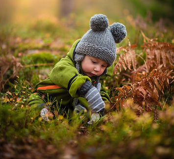 petit garçon joue dans l'herbe en automne