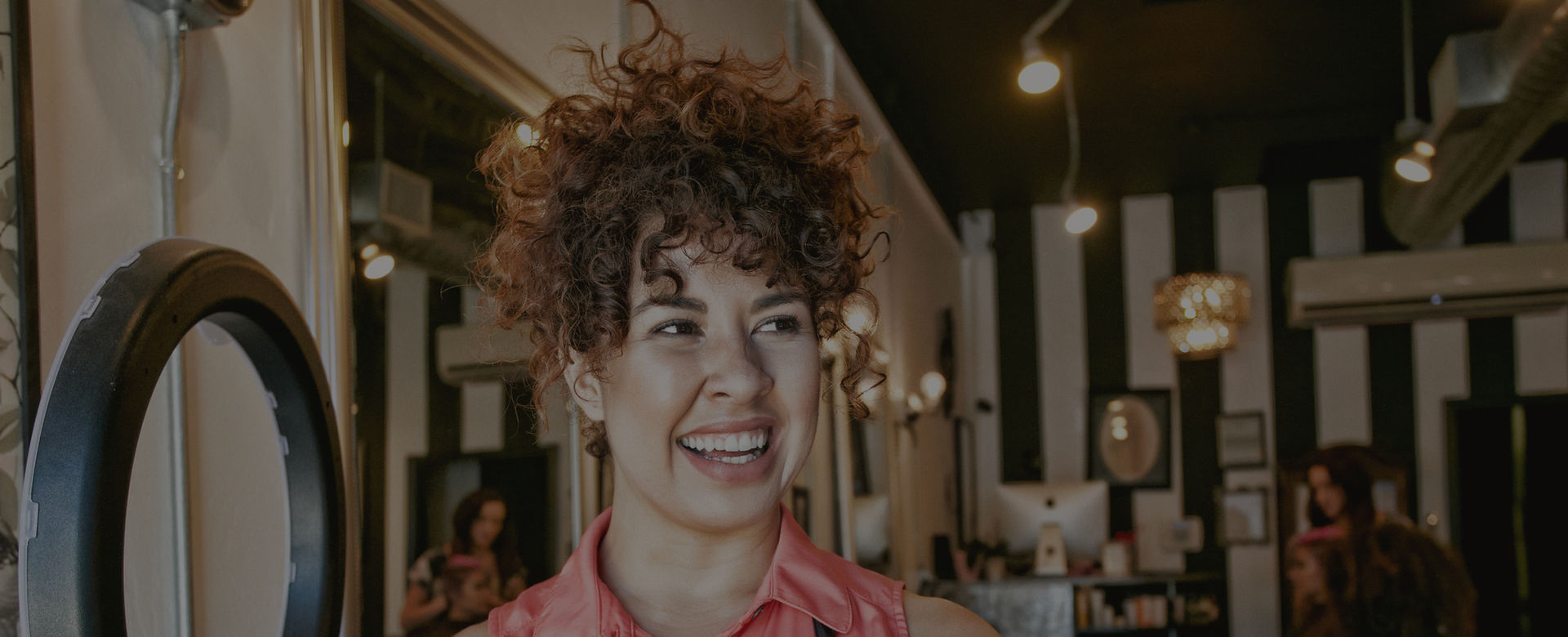 A small business owner smiles in her salon after choosing SparkBox