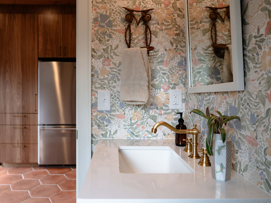 Bathroom vanity with floral wallpaper, brass faucet, owl