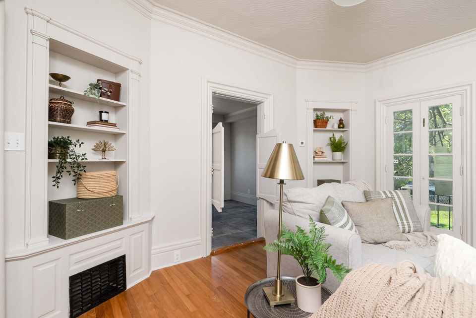 Bright living room with built-in shelves, couch, and wood floor