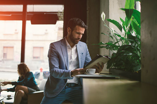 Man reading a book in a cafe to relax in his lunch break