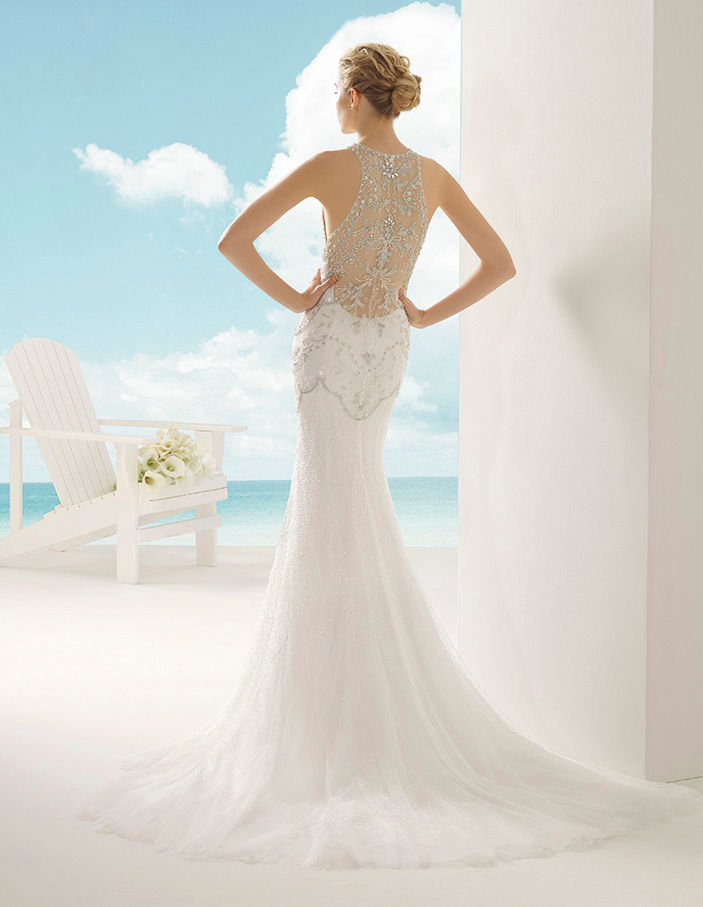 Sposa con abito bianco, vista posteriore, spiaggia e cielo blu. Sposami Atelier