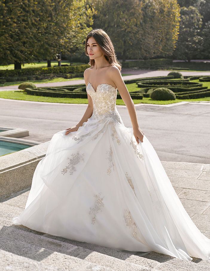 Modella in abito da sposa, Sposami Atelier, cammina su una scalinata, elegante.