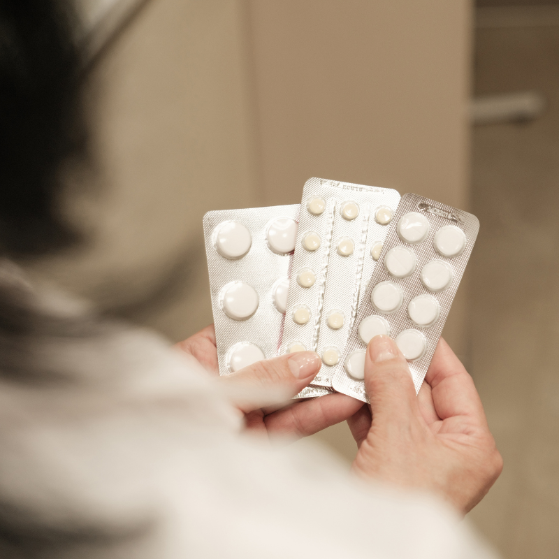 Hand holding a blister pack to represent compliance packaging services.