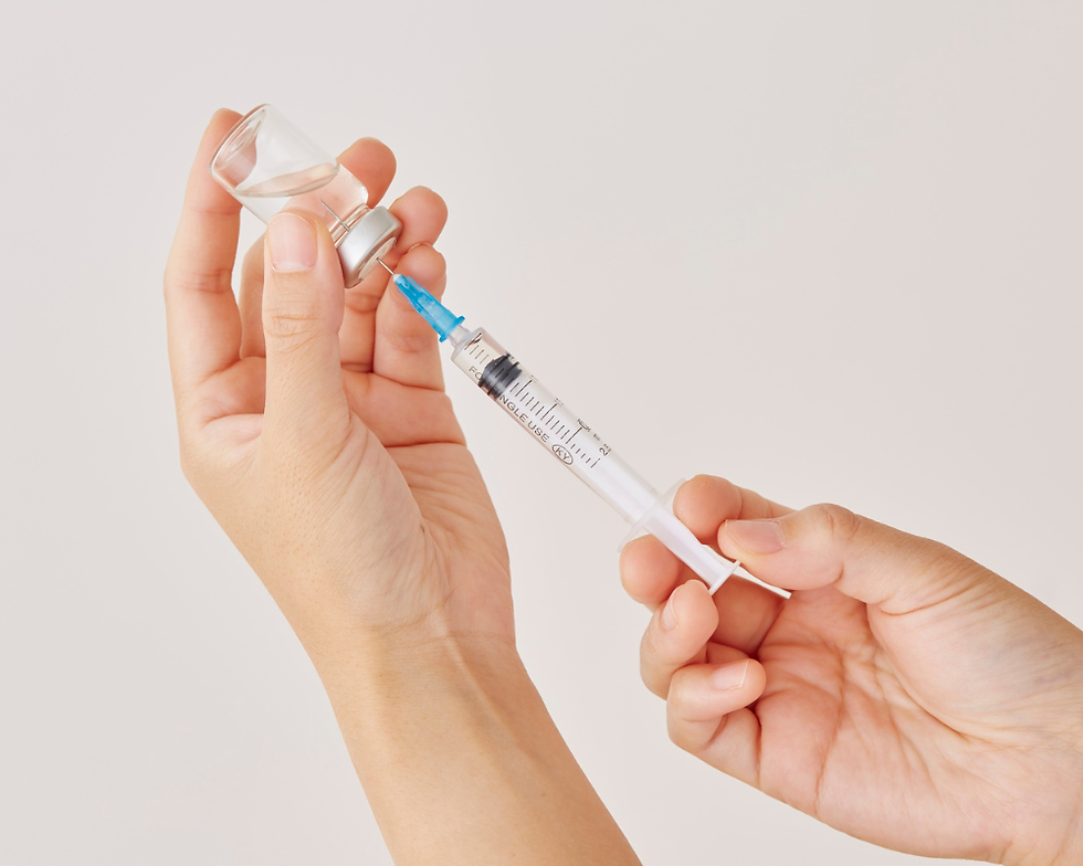 Close-up of hands preparing a syringe for vaccination