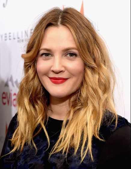Drew Barrymore with fresh, dewy skin in a natural makeup look, exemplifying her signature low-maintenance skincare style.